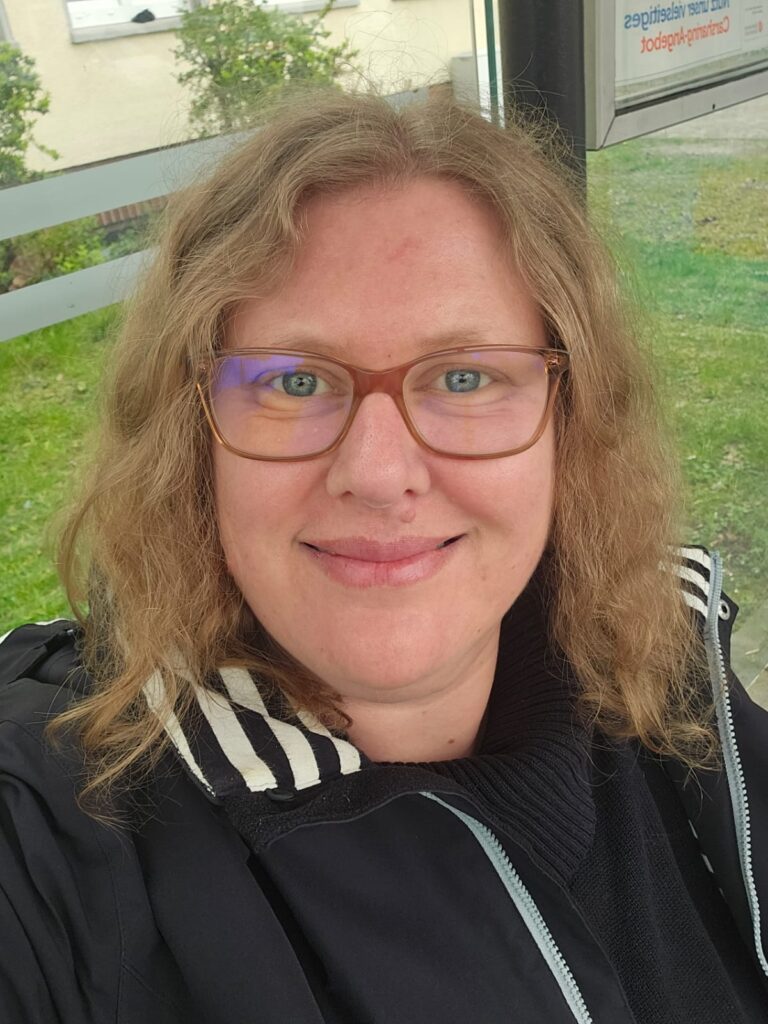 Eine Frau mit Brille und halblangen blonden Haaren